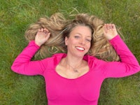 a woman laying on the grass with her head down