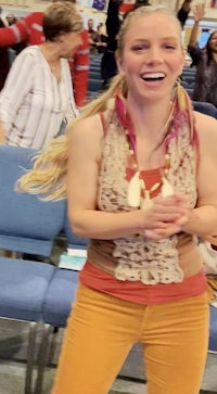 a woman is standing in a church with a smile on her face